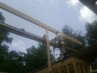 Carpenter setting a ridge beam over a new addition frame — Ice Dam Removal by Roofing Brothers in Wapakoneta