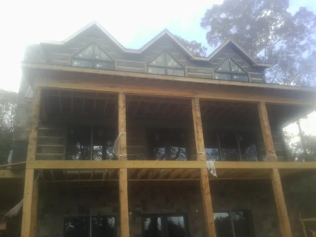 Dormers and porch framing on a large log home under construction — Roof Coating work by our crew in Wapakoneta